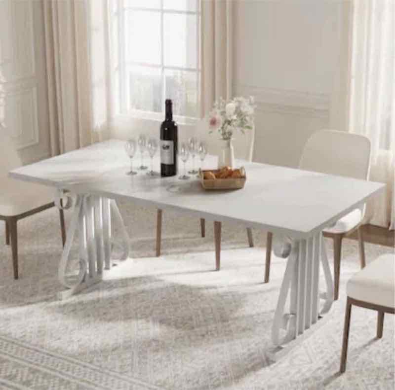 White faux-marble top dining table with pedestal base and cream chairs