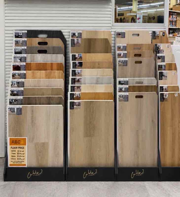 123 Home Outlet vinyl plank flooring display with floor-price sign listing per-square-foot pricing