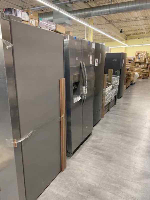 Row of stainless steel French-door refrigerators in the warehouse appliance aisle