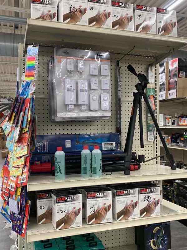 Power tools, hand tools and a tripod stand on warehouse hardware shelves
